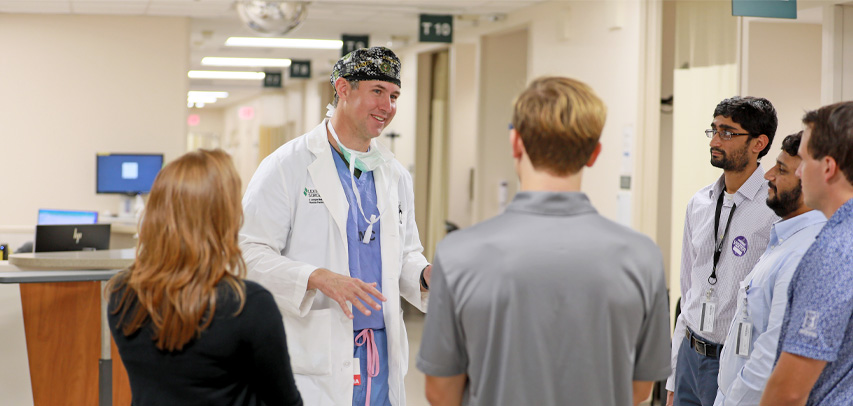 Dr. Webb chatting with a group of residents on the hospital floor.