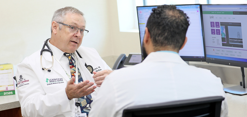 Dr. Mayeaux talking with a fellow.