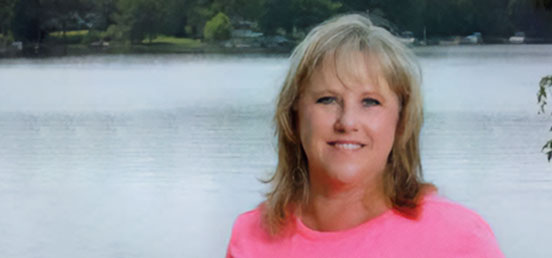 Photo of double hip replacement patient Shoandra Fagg in front of a lake.